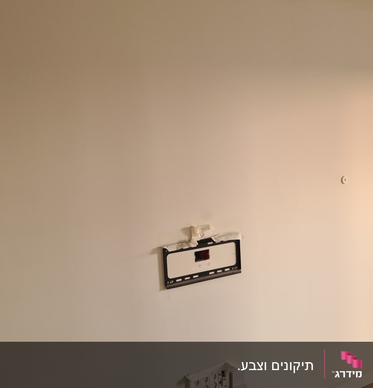 קיר צבוע בלבן עם מסגרת מתכתית